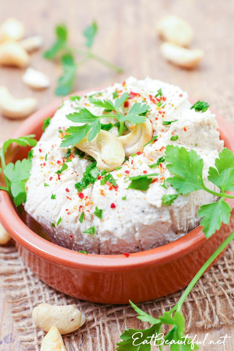 dish of cashew nut cheese with fresh herbs