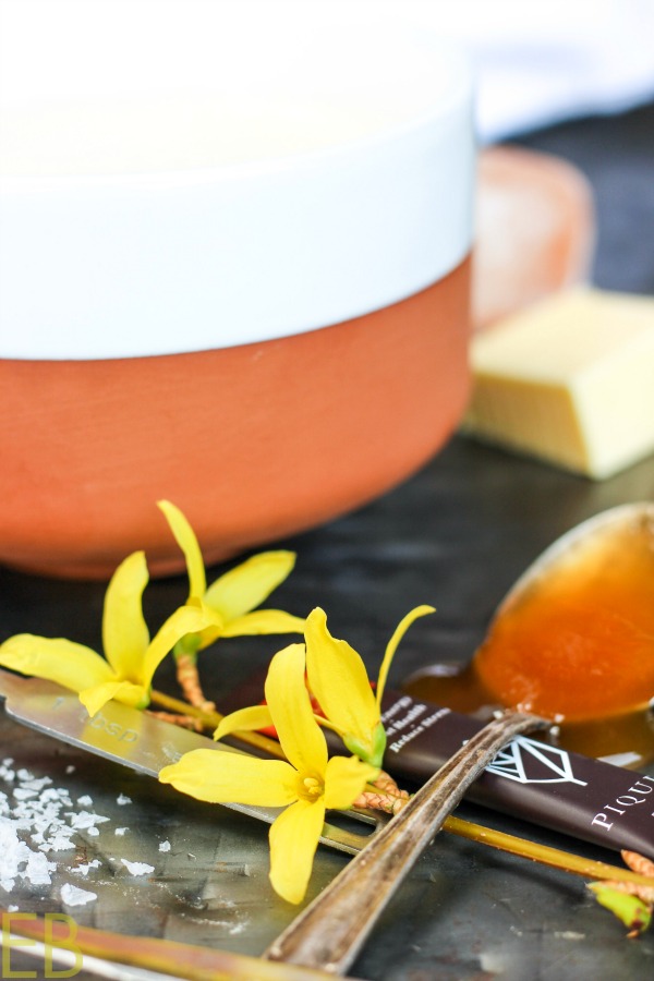 forsythia blossoms and honey in front of cup of butter tea