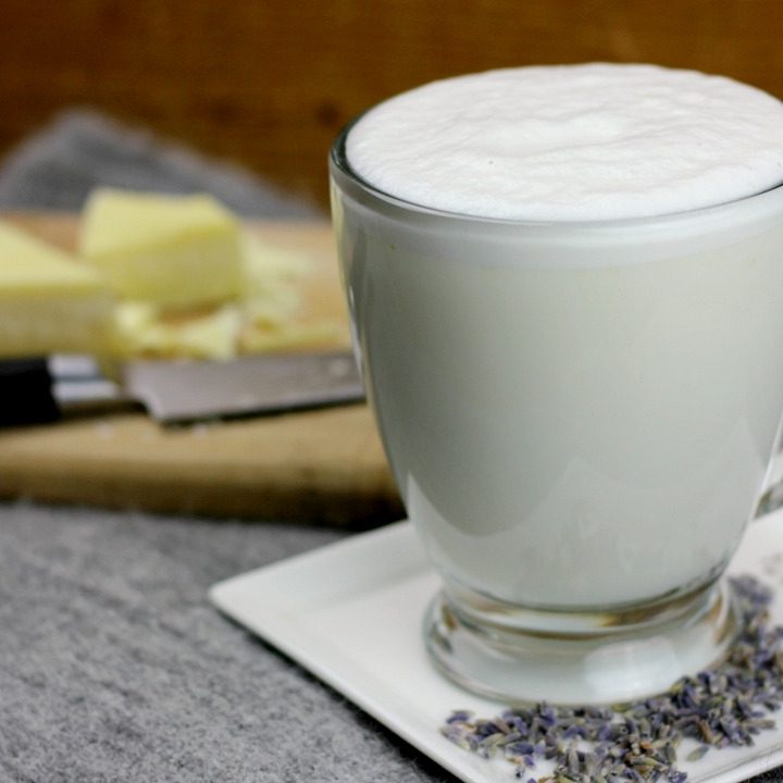 close up view of white hot chocolate with cocoa butter in the back ground