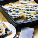 a big square cut out of a aip and paleo lemon blueberry coffeecake and served on a small white plate