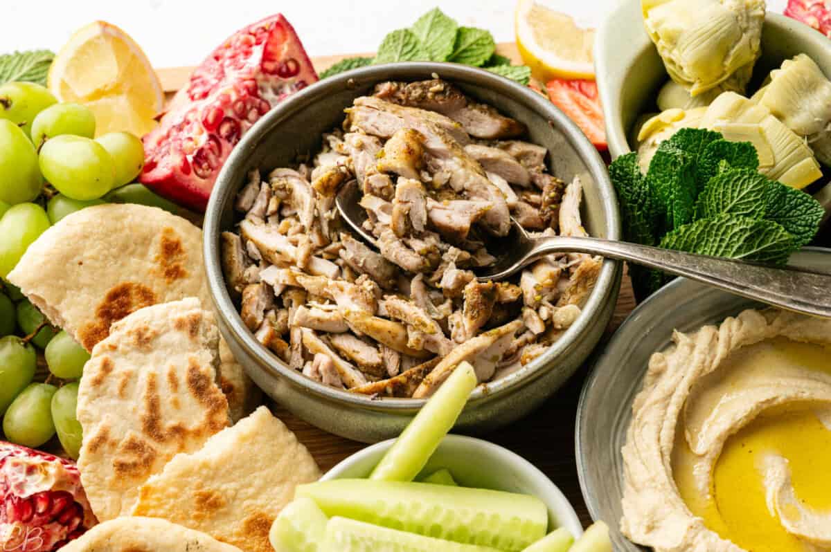 za'atar chicken thighs sliced amidst a mezza platter
