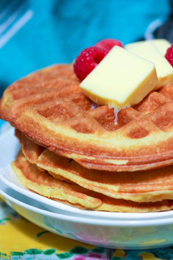 a stack of keto coconut flour waffles with butter and berries on top