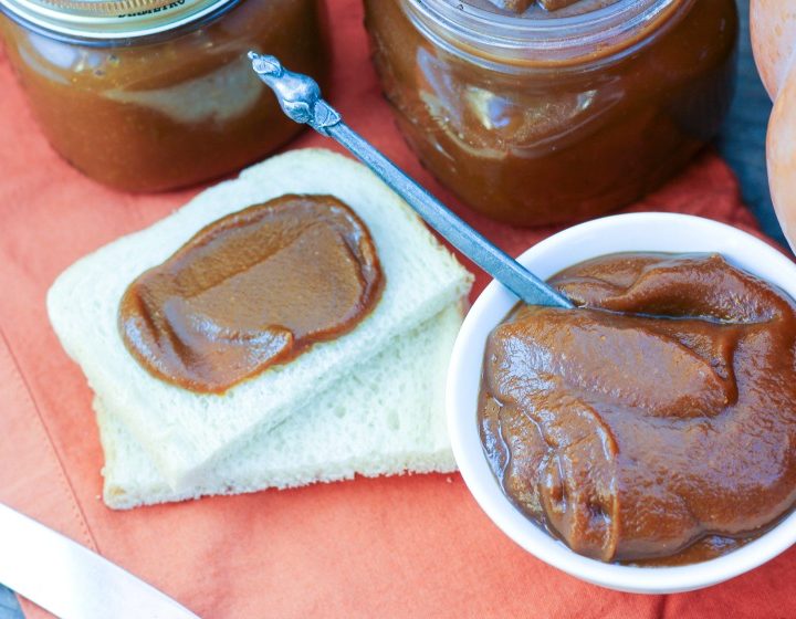 Instant Pot Paleo Pumpkin Butter in a bowl and spread on bread, with jars and a pumpkin in the background