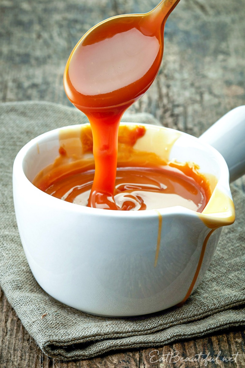 spoon pouring paleo aip caramel sauce into serving dish