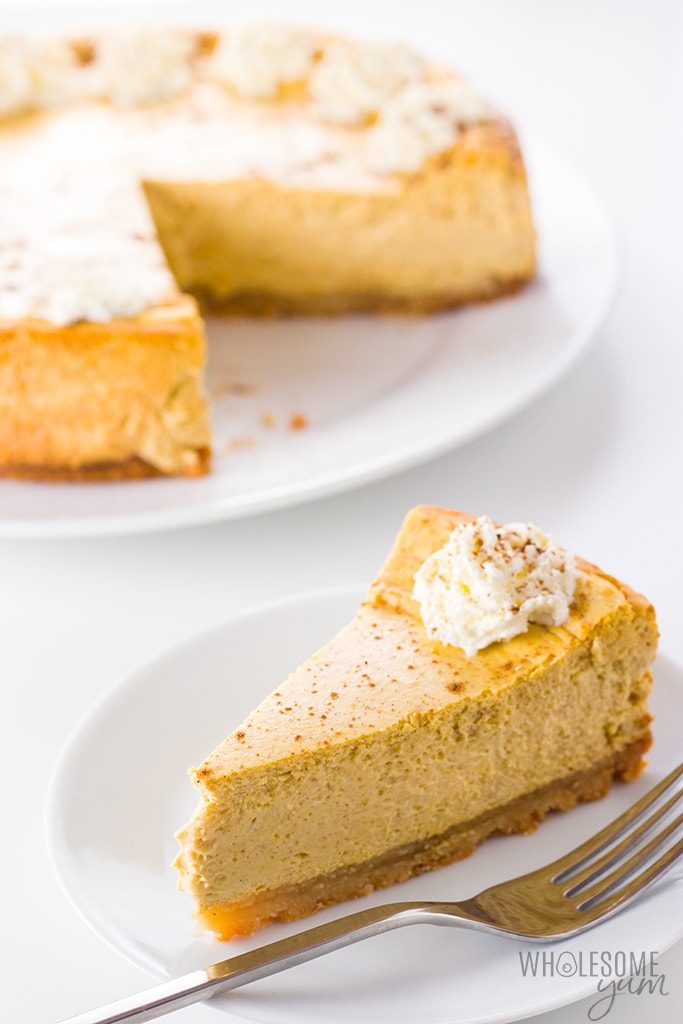 slice of low carb keto pumpkin cheesecake with whole cheesecake in background