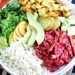 BBQ chicken salad bowl in white dish with all the toppings including avocado, roasted veggies and cauli rice. This dish is Paleo, AIP and GAPS diet.