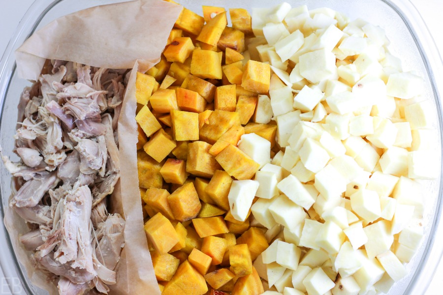 a glass storage container with cooked chicken and cubed root veggies; all this got prepped a day before the recipe was assembled to make it easier the night it was served.