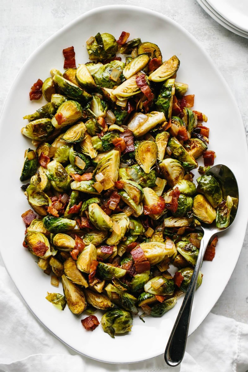 overhead view of Brussels sprouts and bacon dish on large white platter