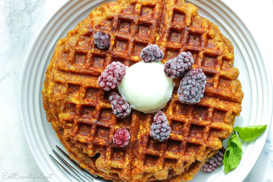 overhead view of plantain waffles with berries on white plate