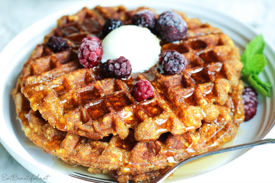 side view of aip waffles on white plate with fresh mint and berries