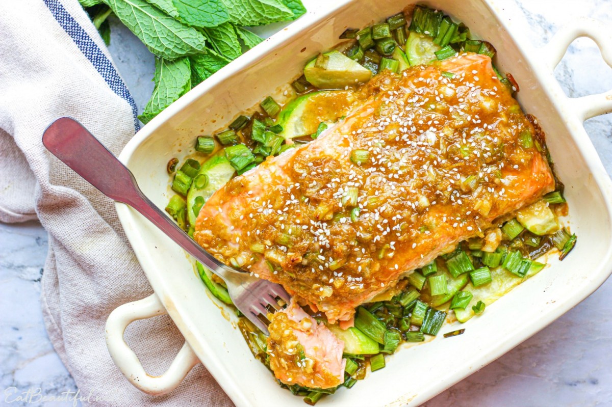 overhead view of ginger-lime salmon in baking dish with fork and one bite taken out