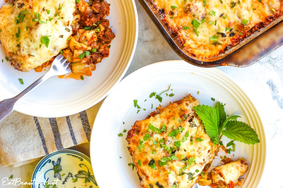 two white plates with mexican lazy cabbage roll casserole served up and casserole dish