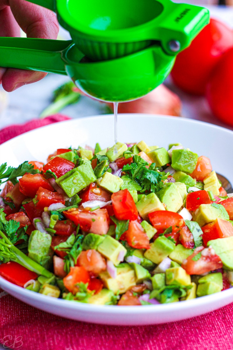 lime juice being squeezed over salsa