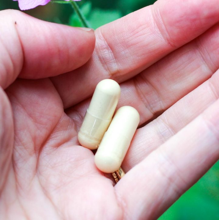 hand holding two DIM capsules