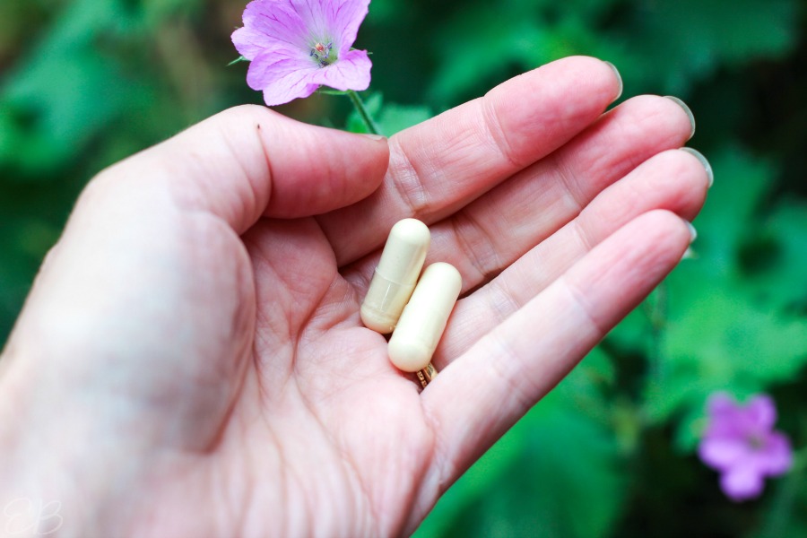 a hand holding two capsules of DIM for insomnia