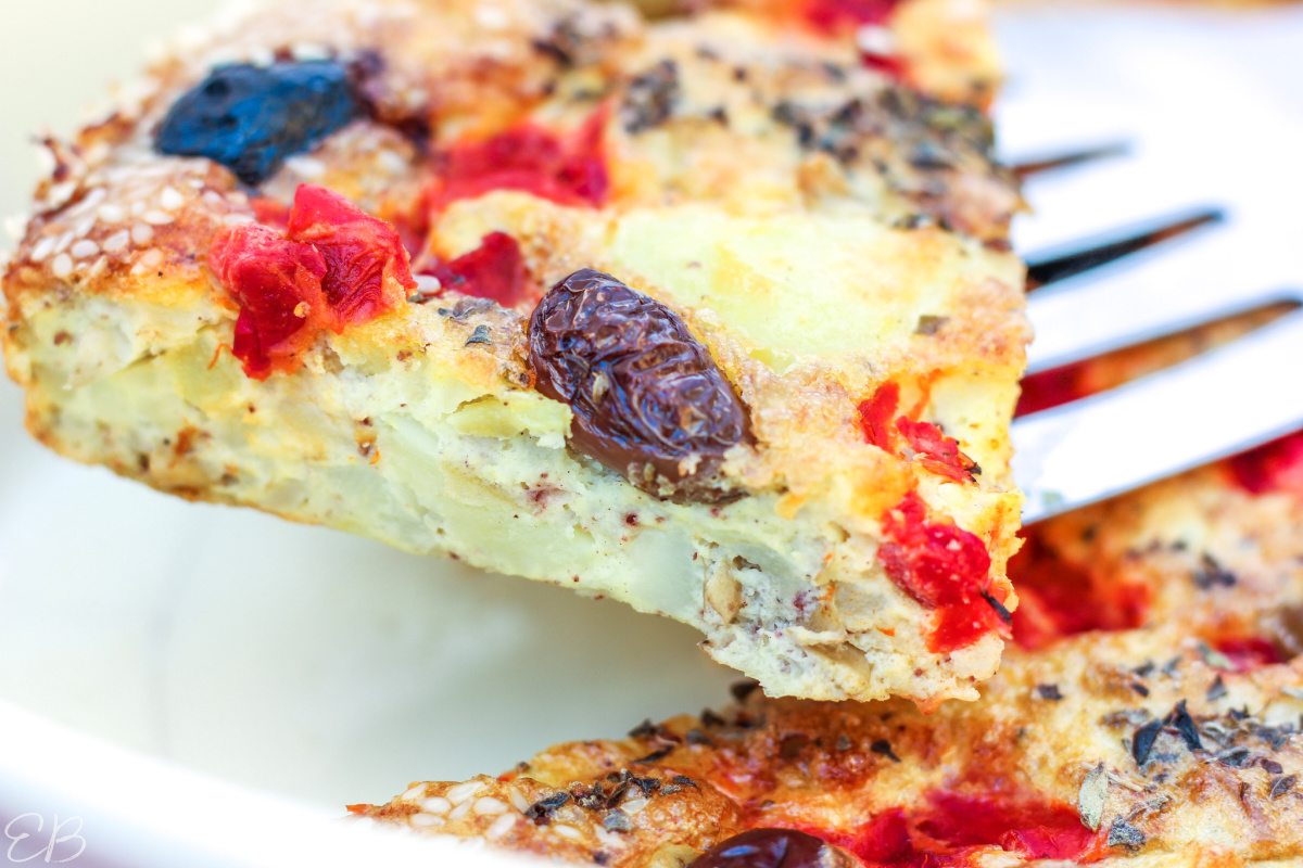 a piece of potato olive crustless quiche being served