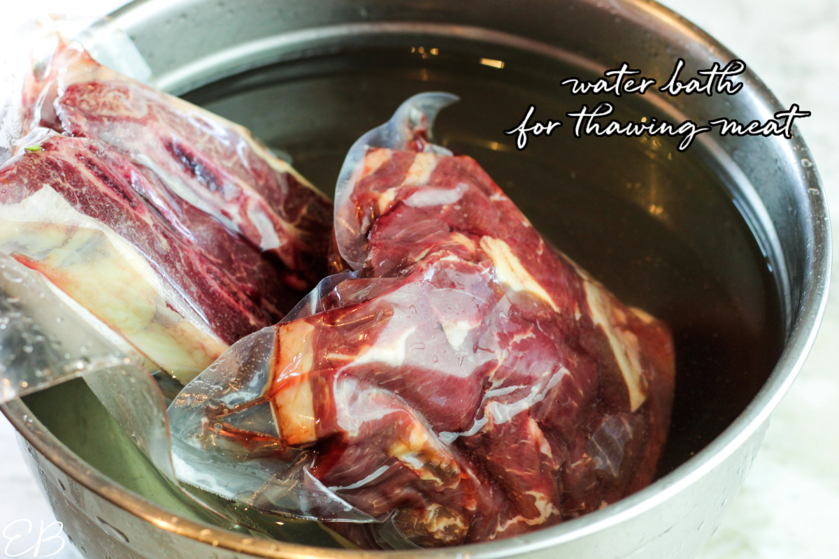 two bags of stew meat defrosting in a water bath