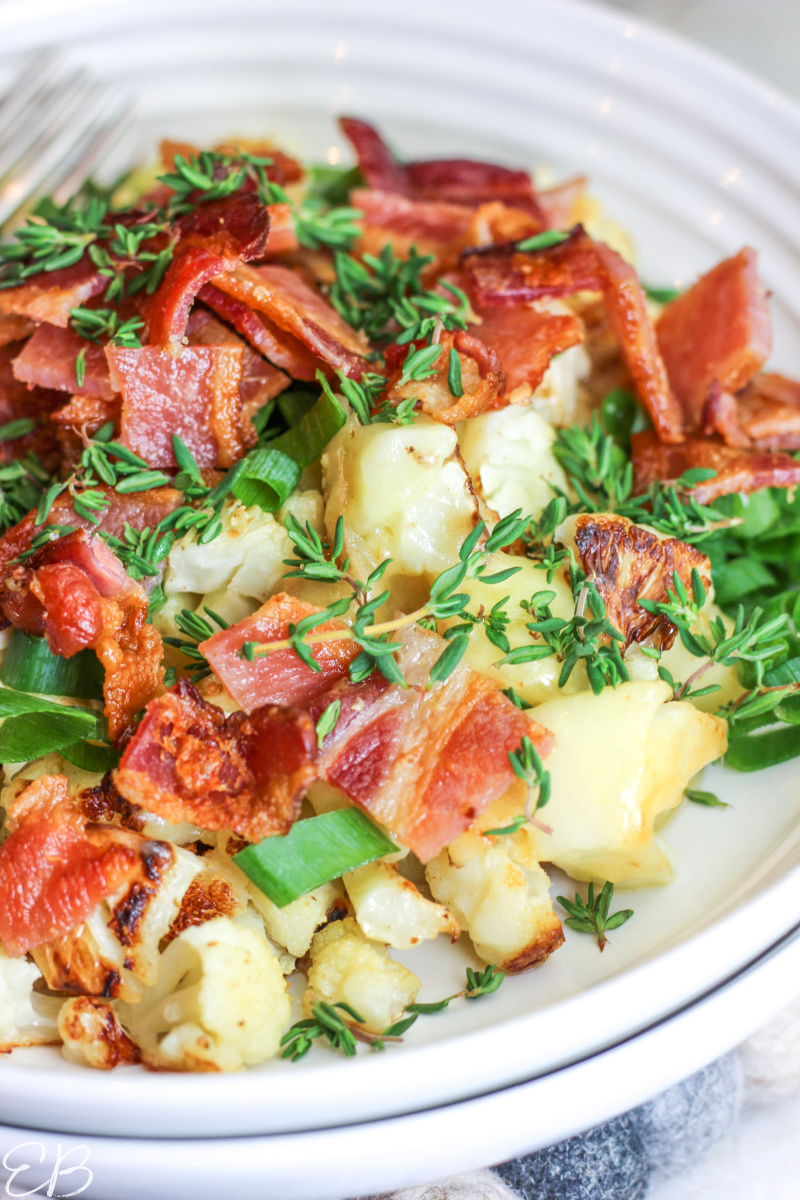 up close image of roasted loaded cauliflower in broad white bowl