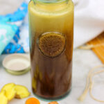 bottle of paleo teriyaki sauce surrounded by ginger, turmeric and garlic
