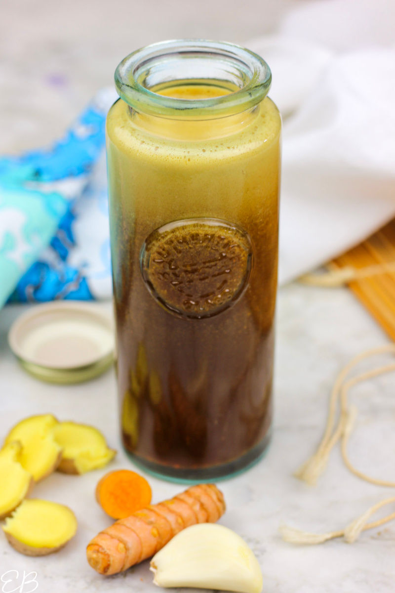 bottle of paleo teriyaki sauce surrounded by ginger, turmeric and garlic