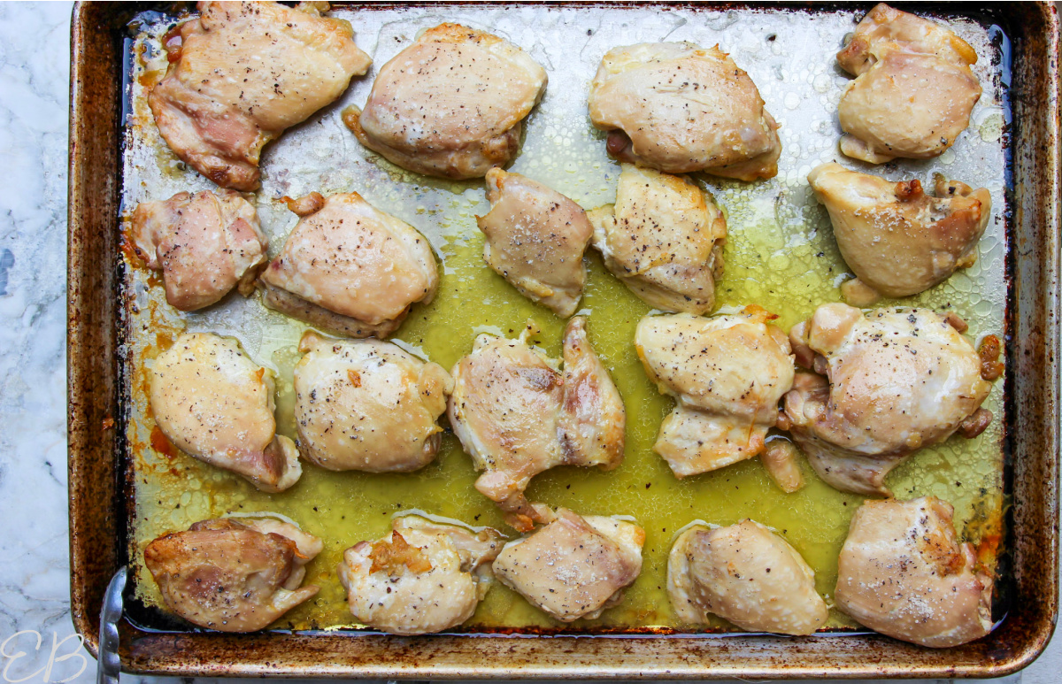 overhead view of baked chicken thighs on sheet pan