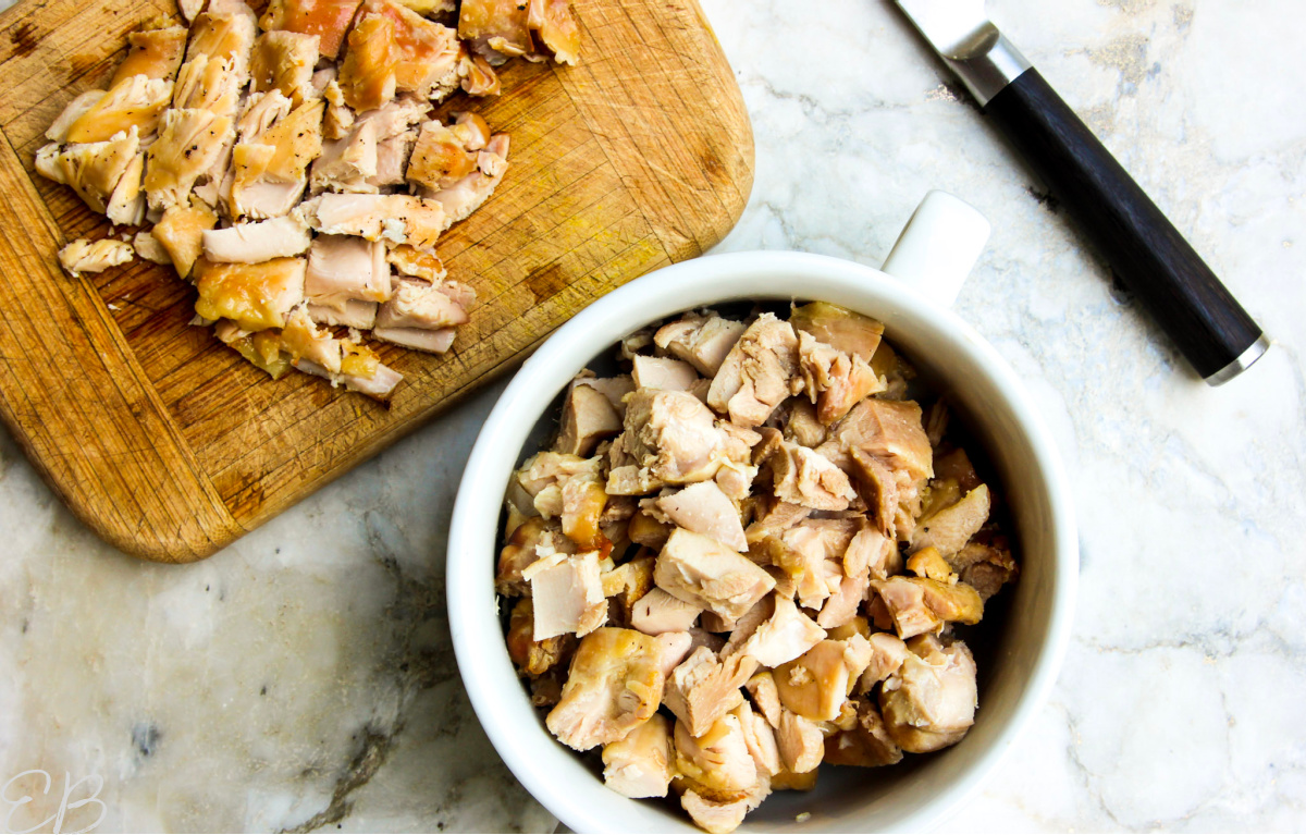 overhead view of chopping process of chicken thigh