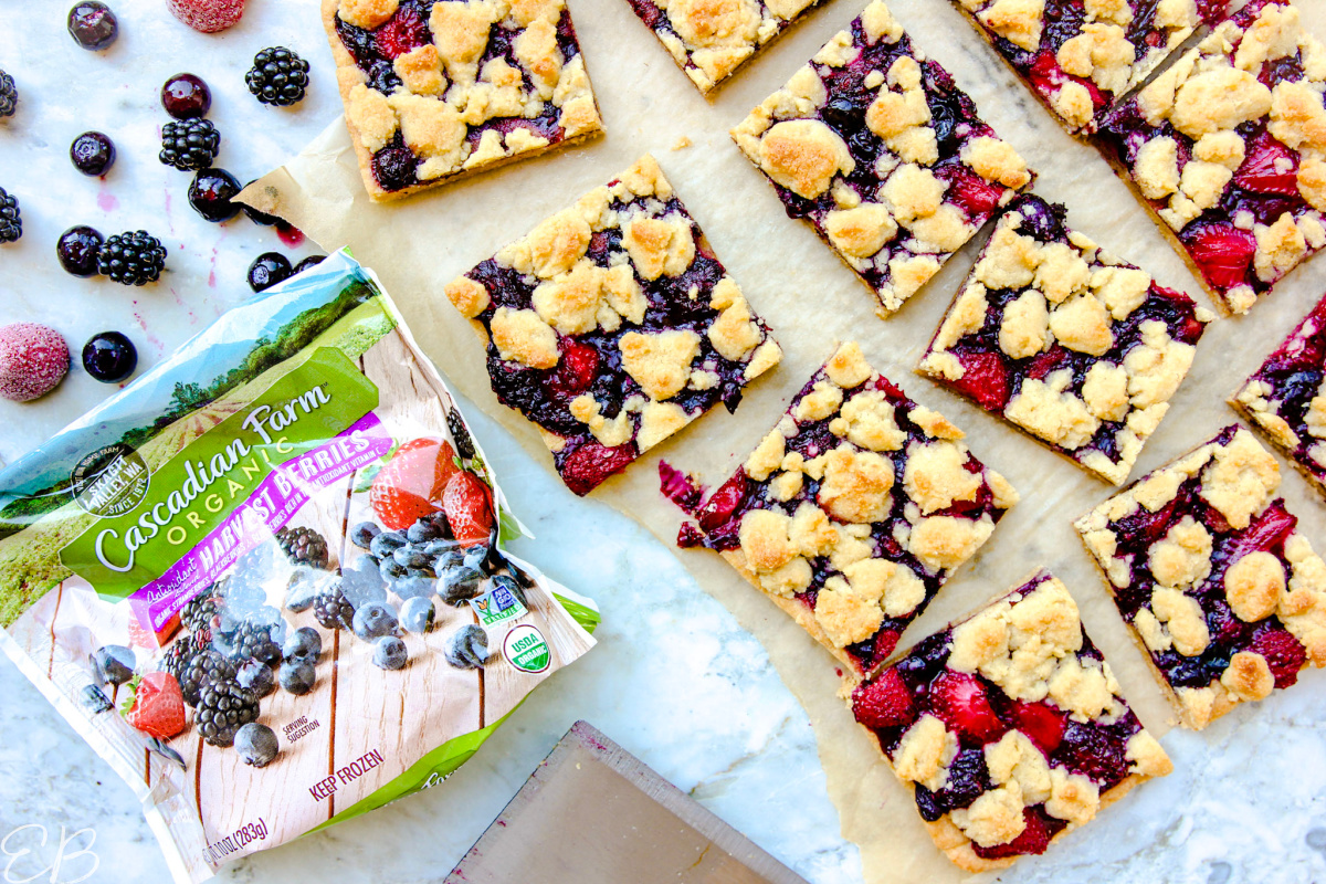 overhead view of berry crumble bars and bag of frozen berries