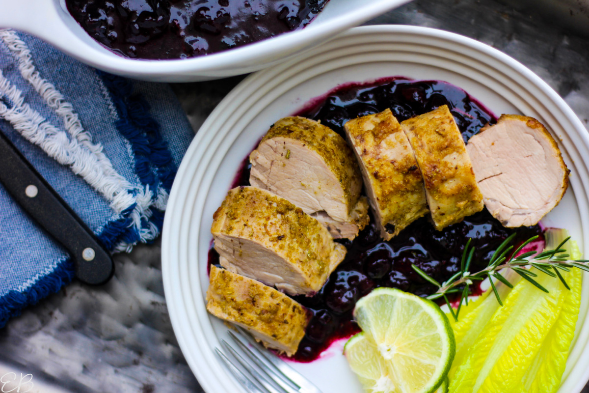 overhead view of pork tenderloin served on blueberry sauce