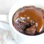 looking down into a mug with one bite out of it of paleo chocolate caramel mug cake