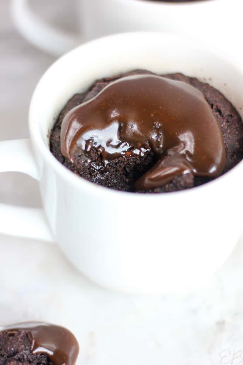 gooey caramel on top of mug cake with a bite taken out