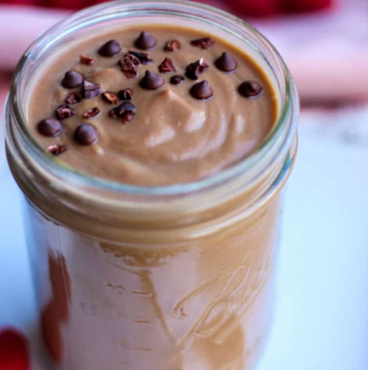 a mason jar with warm chocolate smoothie for weight loss in it, topped with chocolate chips