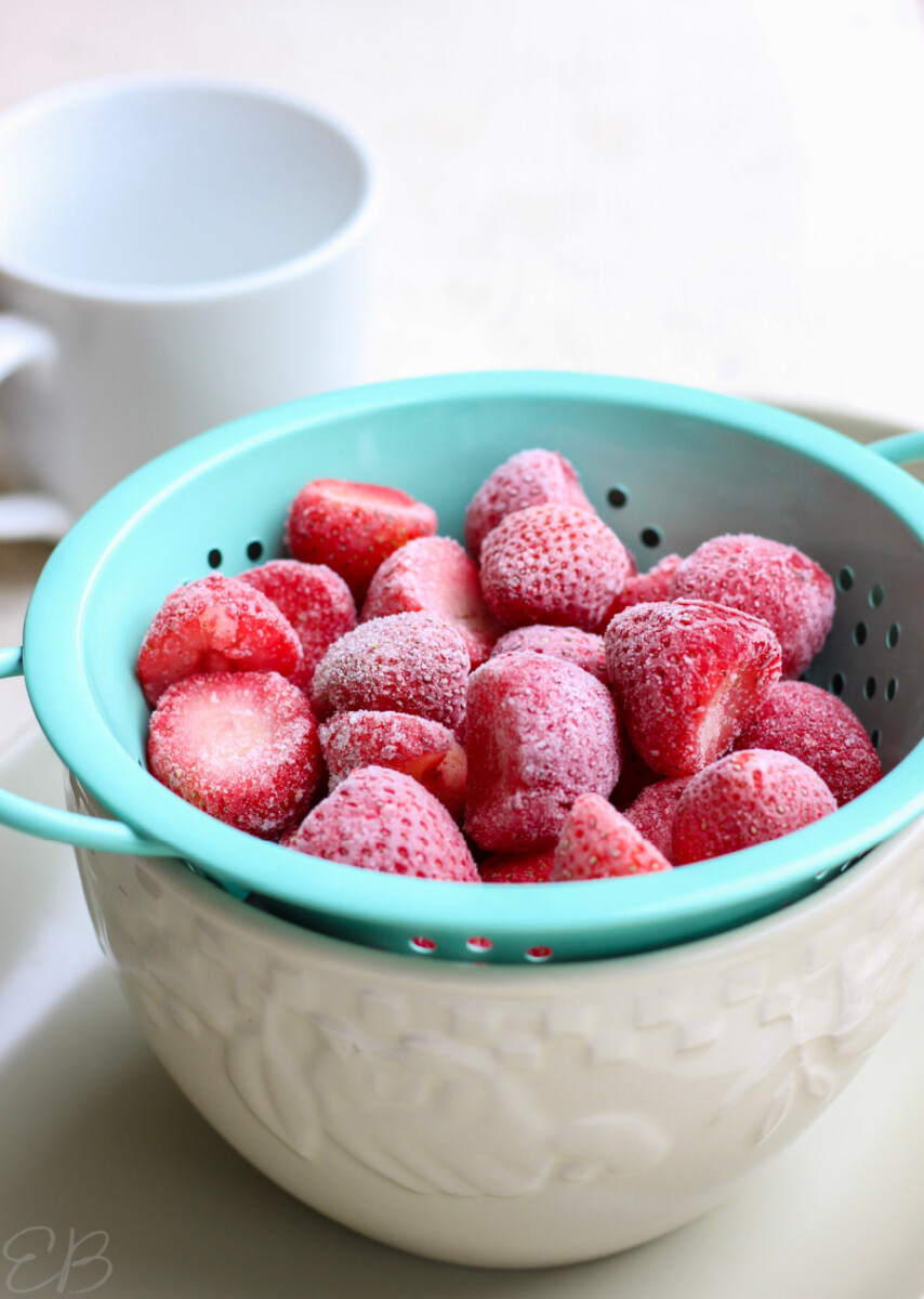 frozen strawberries defrosting in a colander
