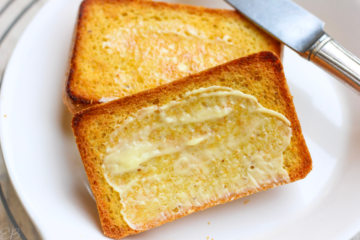 2 slices of keto 90-second bread, topped with butter on a white plate