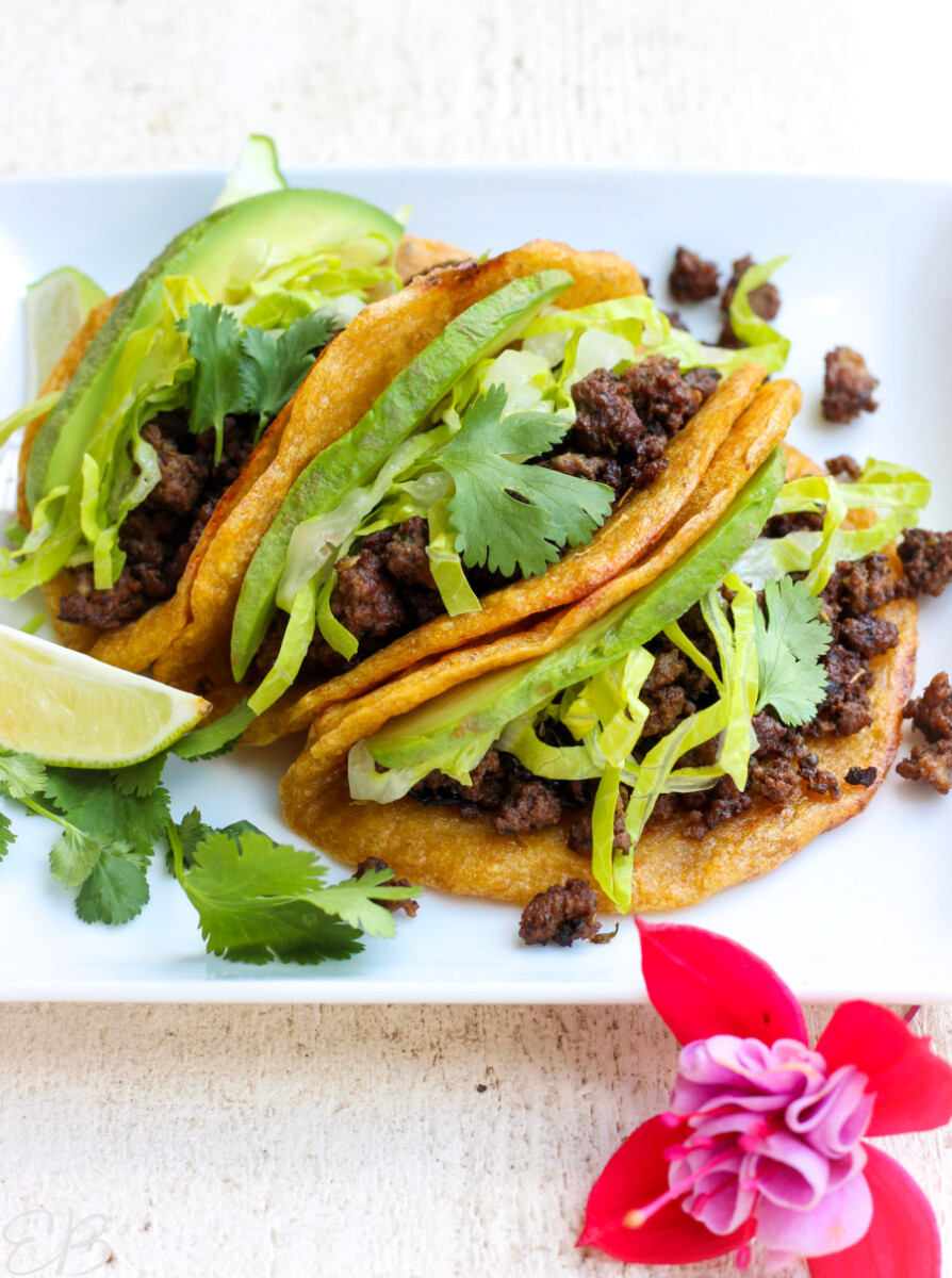 3 tacos lined up with mexican ground beef inside