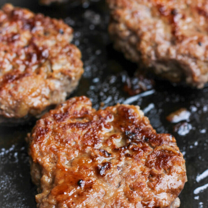 close up of meat sausages fried in pan