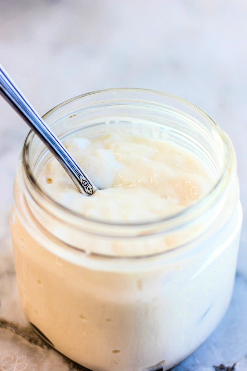 side angle view of mason jar with homemade coconut milk yogurt and spoon