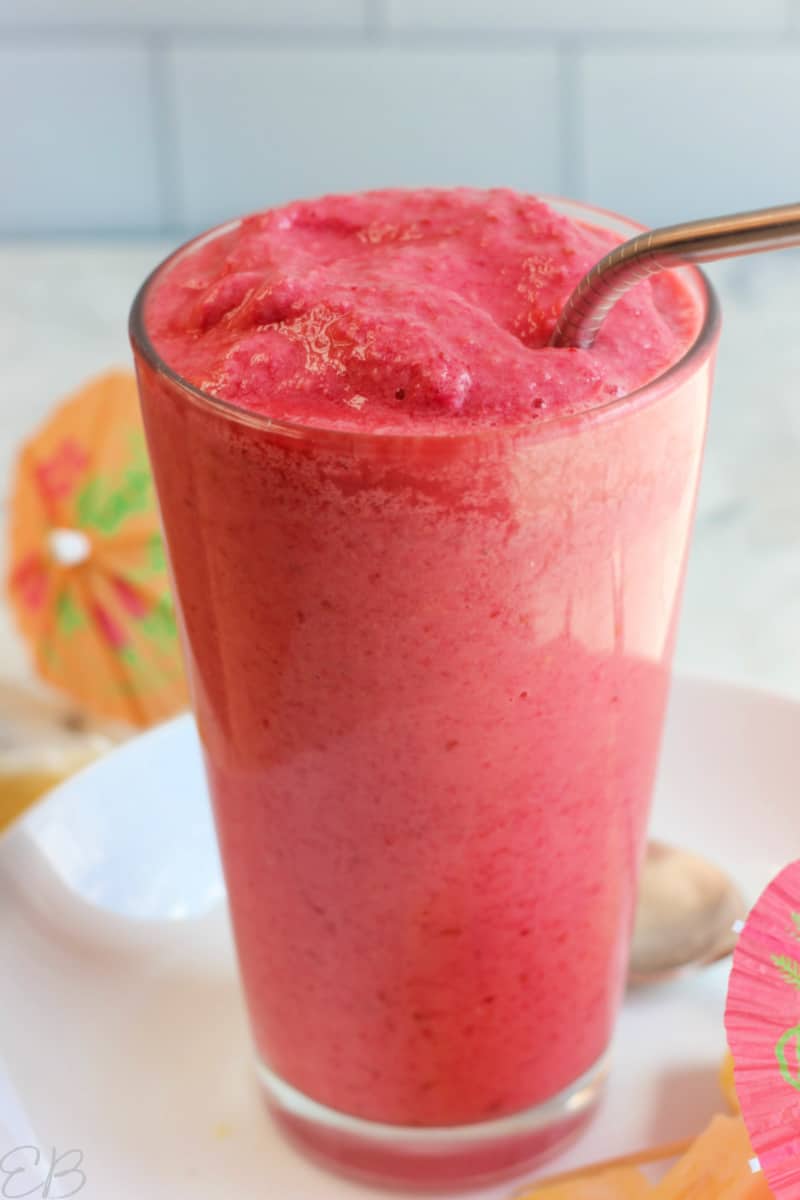 up close photo of low fodmap tropical berry smoothie in tall clear glass