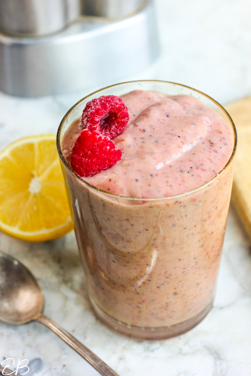 keto smoothie in glass topped with raspberry garnish