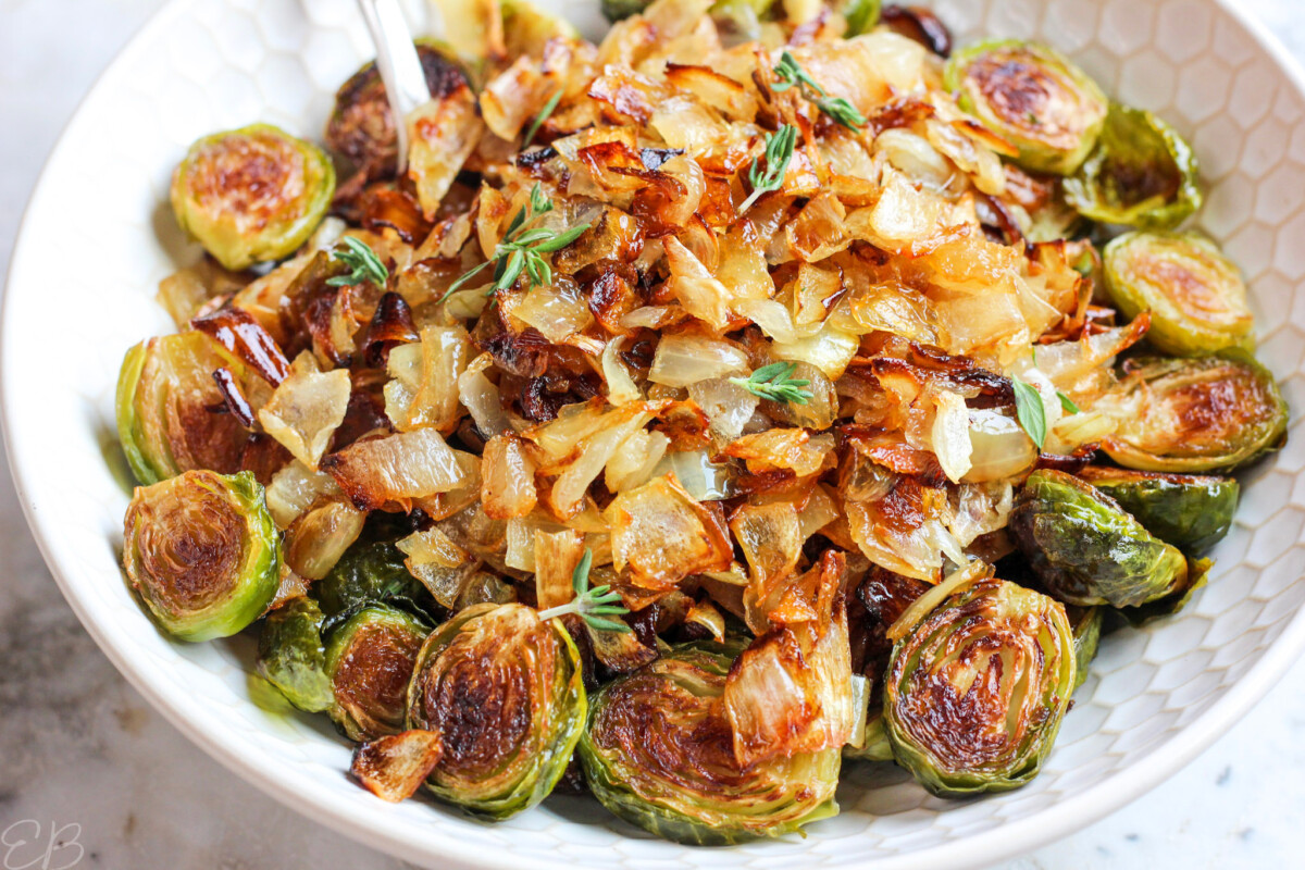 up close photo of brussels sprouts and onions in serving bowl