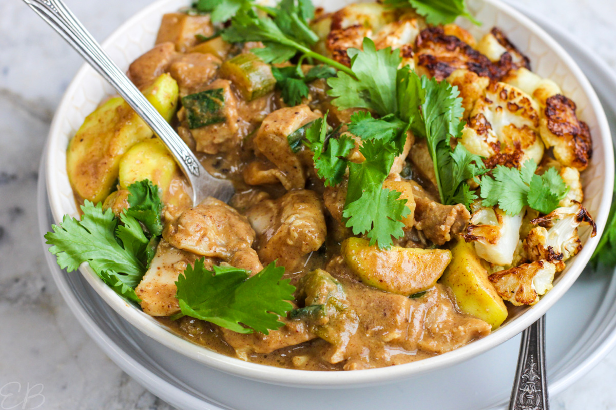 spoon dipped into African Chicken Groundnut Stew