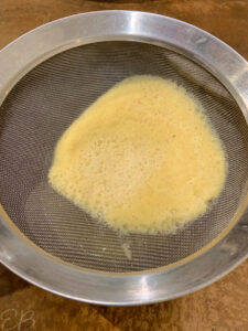 straining ginger pulp through sieve