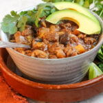 rustic bowl with best aip chili in it topped with fresh cilantro and avocado