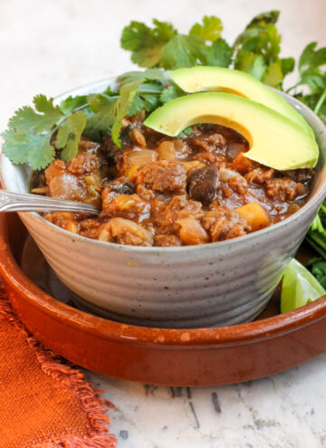 rustic bowl with best aip chili in it topped with fresh cilantro and avocado