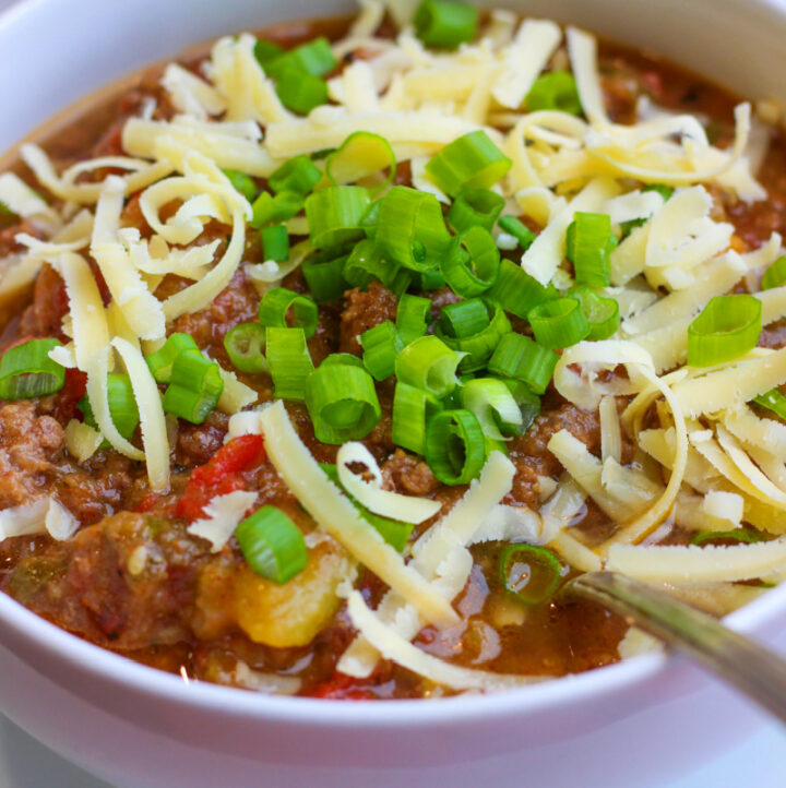 low fodmap chili topped with cheese in white bowl