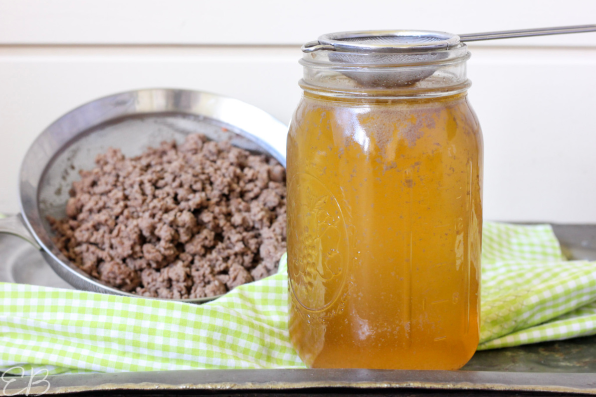 jar of meat stock with ground beef in the background