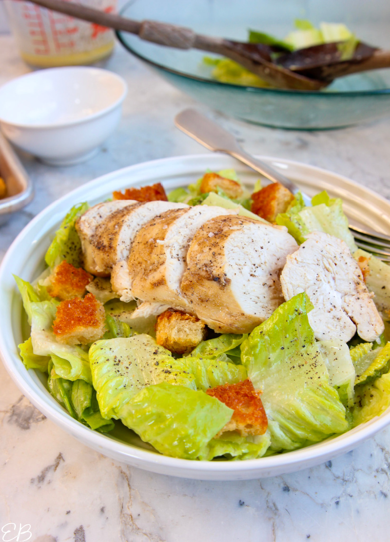 anti inflammatory caesar salad plated with chicken breast on top