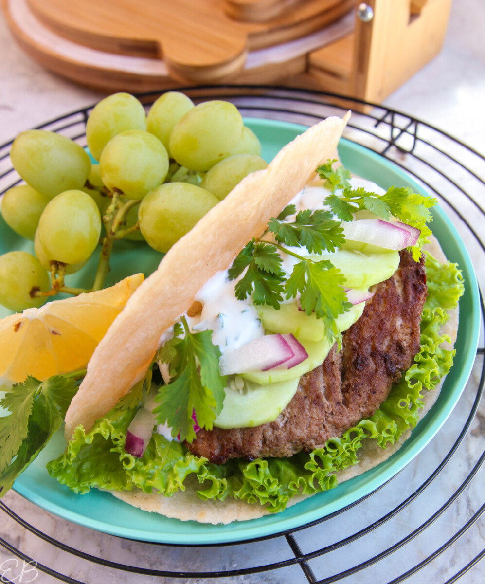 side angle view of paleo ground turkey gyros on plate with grapes and lemon wedge