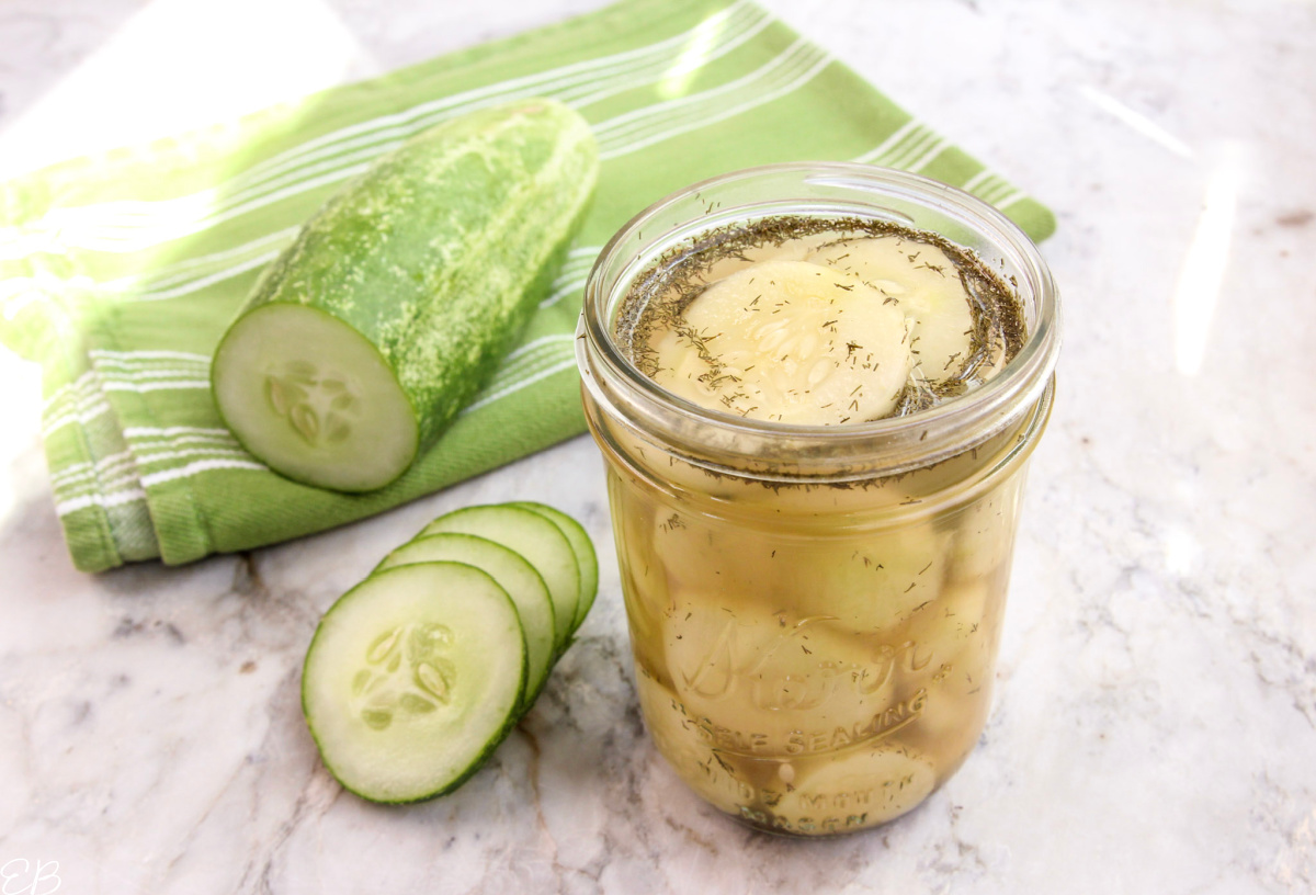 jar of quick pickles with no sugar and a raw cucumber next to