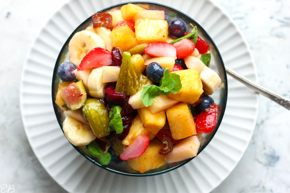 overhead view of heaping bowl full of low oxalate fruit salad with serving spoon