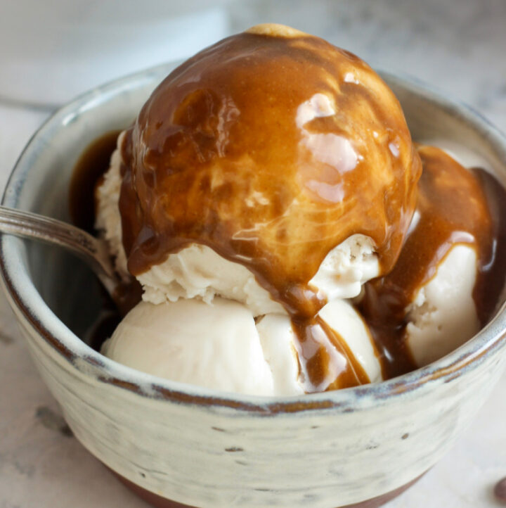 paleo vegan aip tiger nut dessert sauce poured over ice cream in bowl with spoon